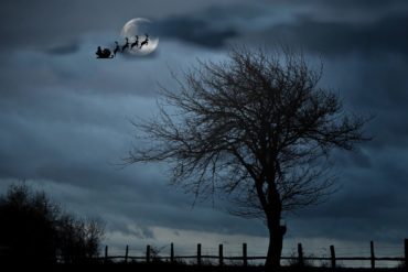 Picture of Santa's sleigh silhouetted against moon