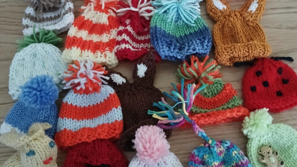 A selection of tiny knitted hats for Age UK Gloucestershire's Big Knit campaign