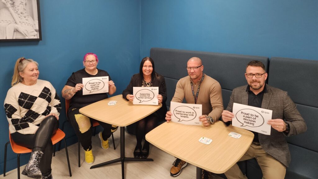 Two members of GCH Scrutiny Group and 3 members of GCH PropertyCare team seated at tables holding up TPAS signs